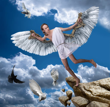 A young man with wings on a background of blue sky.