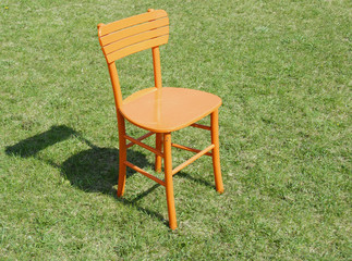Orange wooden chair on grass