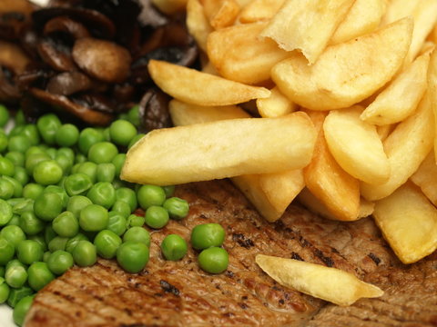 Close-up of steak with chips and peas.