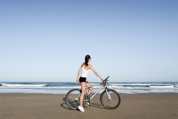 Frau mit Fahhrad am Strand