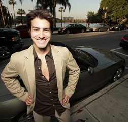 Man smiling next to his sports car