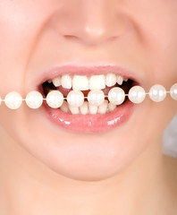 Teeth biting on faux pearls