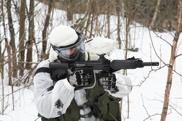 Fototapeta premium armed men in a camouflage play a paintball