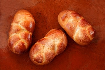 Three brioche pastries over orange clay