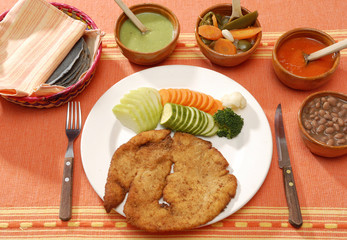 Pechuga de pollo empanizada acompañada con vegetales. México