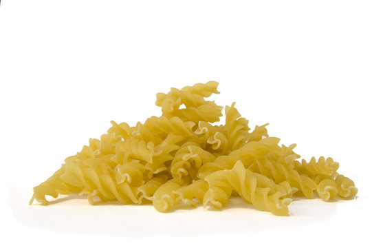 A pile of dried fusilli pasta twirls on white
