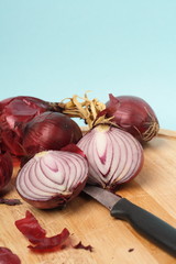 rote zwiebeln auf einem holzbrett