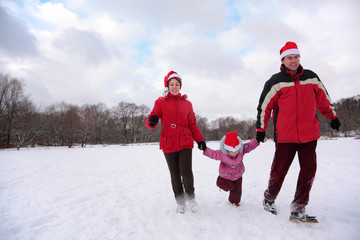 Parents with child run in park in winter