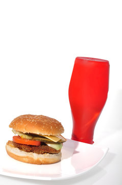 Hamburger on white plate and bottle of ketchup