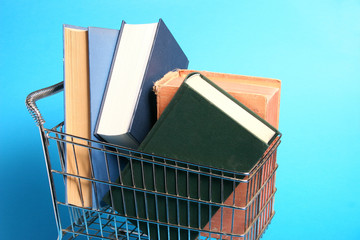 particolare carrello della spesa pieno di libri