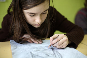 Girl drawing using pencil