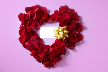 Red rose petals in heart shape, copy space blank note