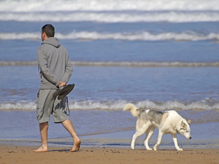 Hombre con perro por la playa