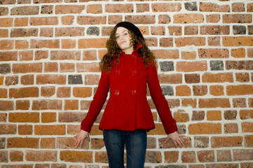 Fototapeta na wymiar Young girl standing at the wall