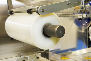 Conveying machine beltlinewith roll of polyethylene film