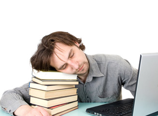 man with books and laptop sleeping