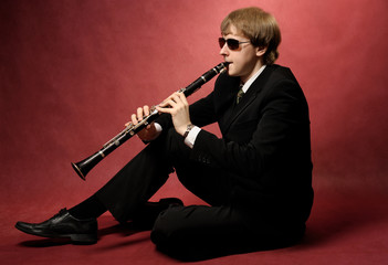 Young male musician plays the clarinet