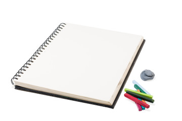 sketchbook and pastel crayons on a white background