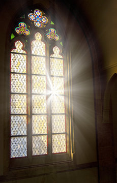 Church stained-glass window with light shining through