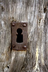 Key hole over aged gray old wood
