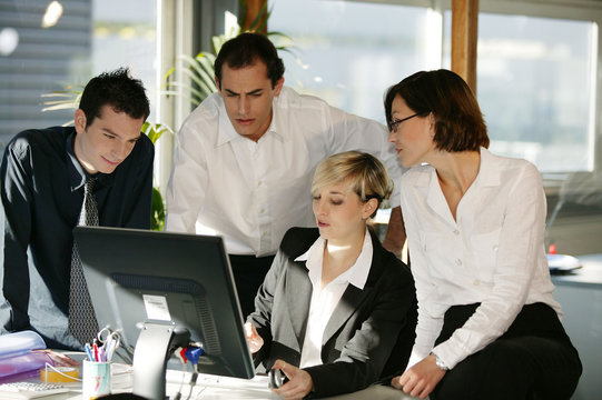 hommes et femmes avec ordinateur de bureau