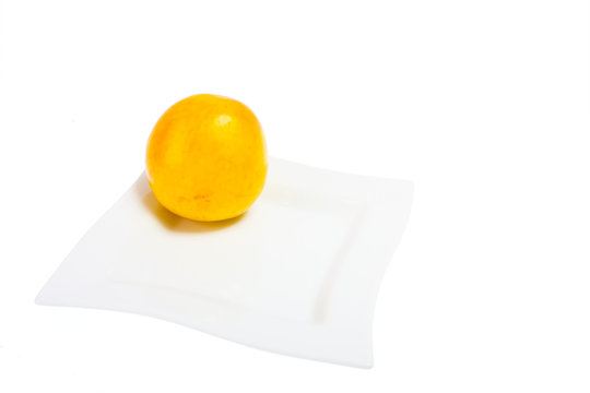 big yellow plum on the white plate