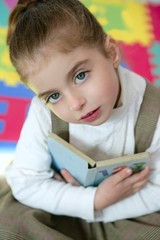 Beautiful preschooler girl studying book