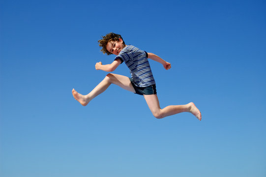 Boy jumping against ble sky