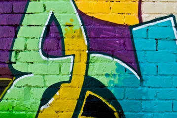Foto op Plexiglas Graffiti Graffiti: kleurrijk detail op een getextureerde bakstenen muur