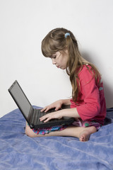 girl seven years old playing with laptop