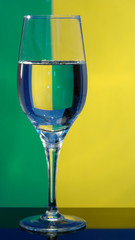 Glass glass with water on a greenish-yellow background