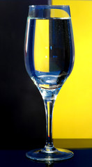 The glass glass with water costs on is yellow a black background