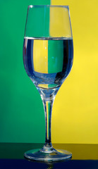 Glass glass with water on a greenish-yellow background