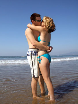 A young kissing couple on the beach