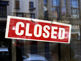 Closed sign in a shop showroom with reflections