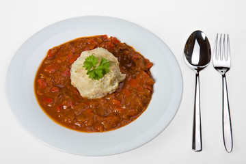 ungarisches Gulasch und Semmelknödel auf einem weißen Teller