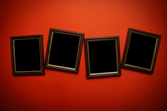 empty picture frames on red wall