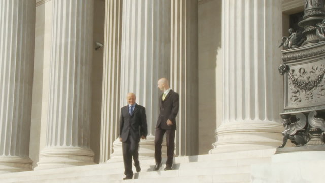 two businessman leaving buidling