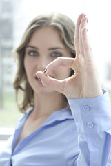 junge frau zeigt mit fingern o.k. und lacht