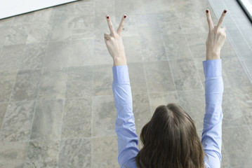 junge frau macht victory zeichen mit fingern