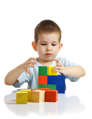 The little boy plays with cubes