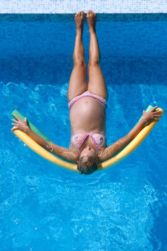 Femme enceinte se relaxant dans la piscine.