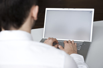 junger geschäftsmann sitzt vor computer monitor