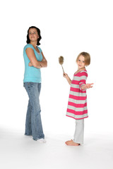 big sister looking away while little sis holds toilet brush