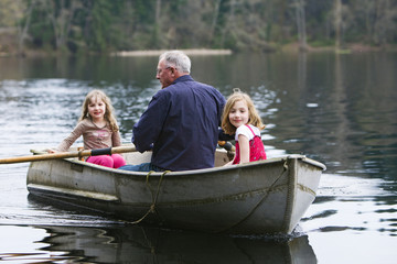 Fototapeta na wymiar Grandpa on Rowboat with Grandchildren