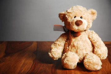 Old fashioned teddy bear on table, dark background