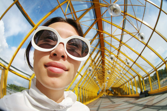 Wide Angle Portrait Of A Young Woman In Sunglasses