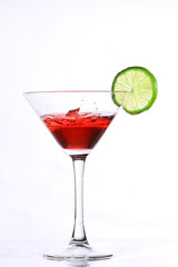 red cocktail with lime on white