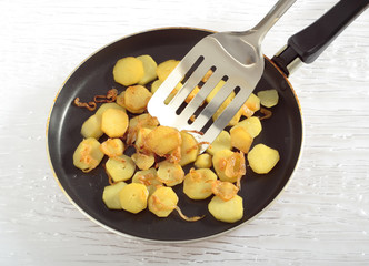 Fried potatoes' slices on frying pan