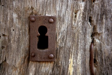 Key hole over aged gray old wood